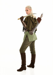 Wall Mural - full length portrait of blonde female model wearing green fantasy elf warrior halloween costume with leather armour. standing pose, holding weapons.  isolated on white studio background.