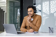 © Tetiana - Young professional wearing headphones and taking notes during a video conference