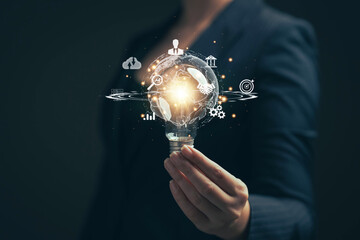 Poster - Light bulb in hand. Big data analysis and business concept with charts and graph icons on digital screen and businessman in the background.