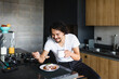© Marcos - latin man eating chilaquiles for mexican breakfast at home in Mexico Latin America, hispanic people
