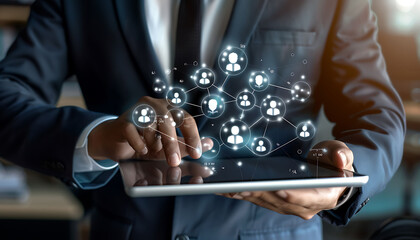 Leinwandbilder - A businessman using a digital tablet to engage with a virtual network of customer and HR icons, demonstrating advanced technology for CRM and recruitment