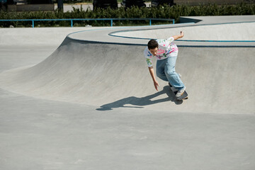 Wall Mural - A young skater boy confidently rides his skateboard up a steep ramp in a sunny outdoor skate park.