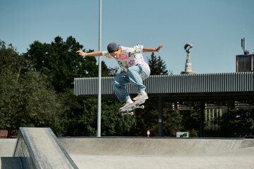 Wall Mural - A young skater boy exhilaratingly skateboards through the air in a summer day at an outdoor skate park.