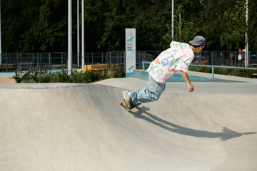 Wall Mural - A young skater boy confidently rides his skateboard up the side of a ramp in a sunny summer skate park.