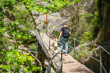 Wall Mural - Father with little girl hiking in Sapadere canyon with wooden paths and cascades of waterfalls in the Taurus mountains, Turkey. Eco tourism concept