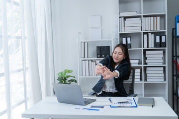 Sharing good business news. Attractive young businesswoman talking on the mobile phone and smiling while sitting at her working place in office and looking at laptop PC.