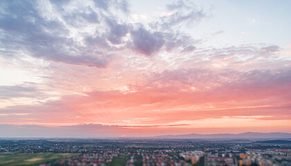 Wall Mural - Bird's eye view of the sunset. Below are fields and villages against a dramatic, beautiful sky.