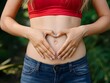 © Kamat - woman holding their belly heart shaped hands
