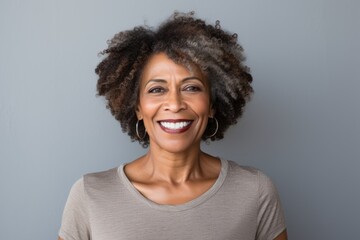 Wall Mural - Portrait of a happy afro-american woman in her 60s smiling at the camera isolated on plain white digital canvas