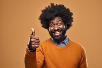 Wall Mural - Portrait of a grinning afro-american man in his 40s showing a thumb up in plain cyclorama studio wall