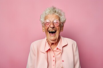 Wall Mural - Portrait of a grinning elderly woman in her 90s laughing over plain cyclorama studio wall