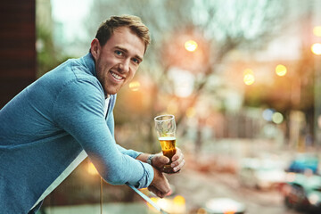 Man, portrait and beer on balcony with smile for relax, celebrate in city for wellness. Male person, alcohol or drink in outdoor for happy hour with glass, cheerful and alone in Chicago with beverage