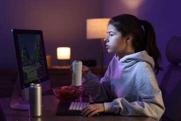 Wall Mural - Girl with energy drink playing computer game at home