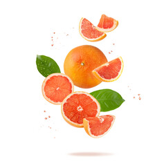 Wall Mural - Fresh grapefruit fruit whole and slices with leaves and drops falling flying