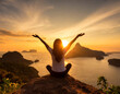 © jobi_pro - Silhouette of woman raising arms to the beautiful sunrise view on the cliff