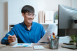 © Garun Studios - document, manager, occupation, paperwork, report, writing, secretary, reading, working, strategy. A man is smiling while reading a piece of paper. He is sitting at a desk with a computer monitor.