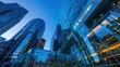 © florynstudio3 - From below of entrance of office building next to contemporary high rise structures with glass mirrored walls and illuminated lights in calgary city against cloudless blue sky