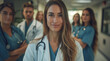 © Creative Art7 - A portrait of an attractive female doctor standing in the middle, smiling and looking at the camera with her team behind her