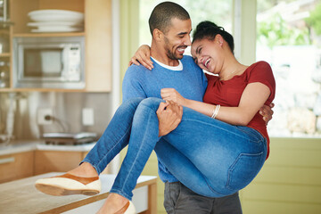 Wall Mural - Happy, man and lifting woman in kitchen with love, care and together with support in apartment. Smile, couple and celebrating for marriage, anniversary and excitement for new home in Los Angeles