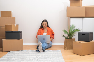 Aufkleber - Attractive woman with dark hair with laptop enjoys moving in fancy apartment looking at various sites for new items for decorating interior of house