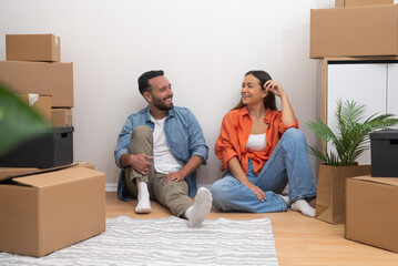 Aufkleber - Married couple enjoys moving in new spacious apartment in another city together sitting with excited expression on floor near wall among cardboard boxes
