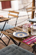 © Natasha Lee - Medium angle of outdoor dining at a cafe in Porto, Portugal, next to a cobblestone street with traditional ceramic plate made by local artisans.