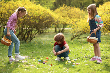 Poster - Easter celebration. Cute little children hunting eggs outdoors