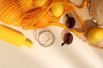 Poster - String bag with sunglasses, fruits and summer accessories on beige background, flat lay. Space for text