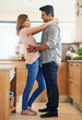 © peopleimages.com - Couple, people and happy with hug in kitchen to relax for bonding, love and support on break together. Home, relationship and romance with smile or laugh for fun, enjoy and care with soulmate