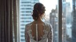 © Irina Ukrainets - Bride Standing by Window Looking at City. Elegant Lace Dress with City View in Background. Perfect for Wedding and Bridal Themes. AI