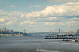 New York, NY, USA - August 1, 2023: George Washington bridge over Hudson river under blue cloudscape. View of New Jersey and Manhattan shorelne with buildings