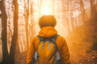 © VisualProduction - Afro-American man hiking through mystical foggy forest at sunset, mysterious atmosphere enhancing the journey.