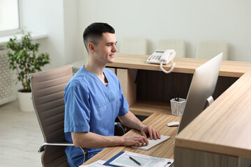 Poster - Smiling medical assistant working with computer at hospital reception