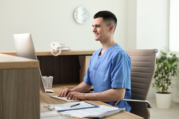 Sticker - Smiling medical assistant working with computer at hospital reception