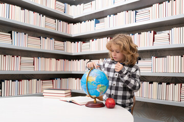 Fototapete - Back to school. School and students in classroom. Education kids. Studying and learning concept. School boy in the library near school supplies. Kid learn geography with globe.