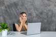 © Vyacheslav - Young woman in elegant attire making poses near laptop and green flower