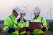 © eakgrungenerd - Team engineer wearing safety uniform holding laptop discussed plan about renewable energy at station energy power wind. technology protect environment reduce global warming problems.