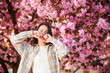 © anatoliy_gleb - Woman allergic suffering from seasonal allergy at spring in blossoming garden at springtime. Young woman having runny nose in front of blooming tree. Spring allergy concept