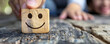 © alexandre - A person holding wooden blocks with smile face for positive customer review satisfaction feedback rating.