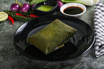 Wall Mural - Asian cuisine - rice with filling in banana leaf