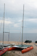 Wall Mural - Catamarans with masts on lake shore.