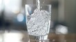 © chanidapa - Refreshing water flowing into a sleek glass, highlighting the importance of staying hydrated.