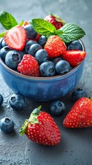 Wall Mural - A blue bowl filled with ripe blueberries and strawberries on a wooden surface. The concept of a healthy breakfast.