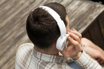 Wall Mural - Attractive young guy listens to music in headphones