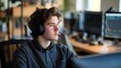 © OZ - Young Man Working in an Office with a Computer and Headphones On