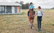 © peopleimages.com - Woman, walking and girl on horse in outdoor for learning, practice or development in countryside. Female trainer, child and together with animal in countryside for lessons, training in Florida USA