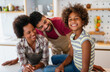 © NDABCREATIVITY - Happy african american parents and child having fun preparing healthy food in kitchen