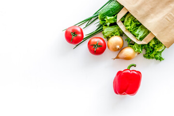 Wall Mural - Healthy food with fresh vegetables in paper bag on white backgro