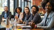 © Svyatoslav Lypynskyy - A group of business professionals gathered around a conference table, engaged in a meeting and discussion.