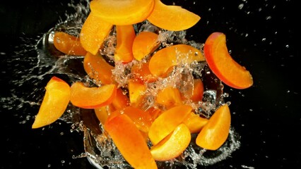 Aufkleber - Super Slow Motion of Falling Apricots Slices into Water, Black Background. Filmed on High Speed Cinema Camera, 1000 fps. Camera Tracking the Target.